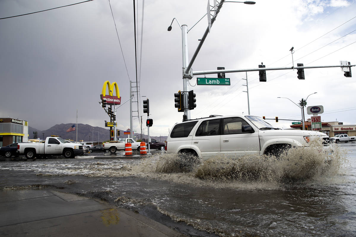 Motorists make way through flooding at the intersection of South Lamb Boulevard and East Charle ...