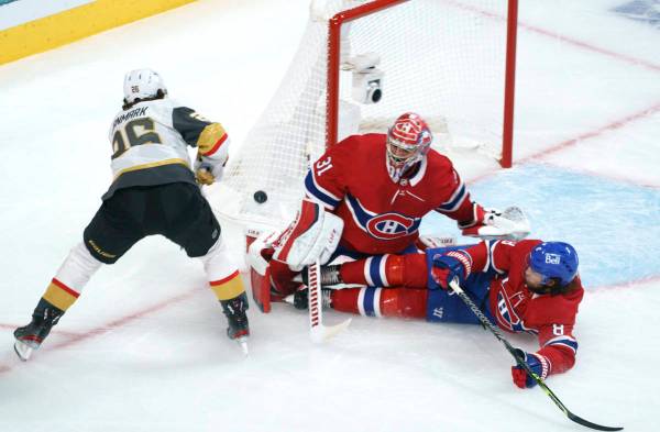 Montreal Canadiens' Ben Chiarot (8) slides into goaltender Carey Price as he makes a save off V ...