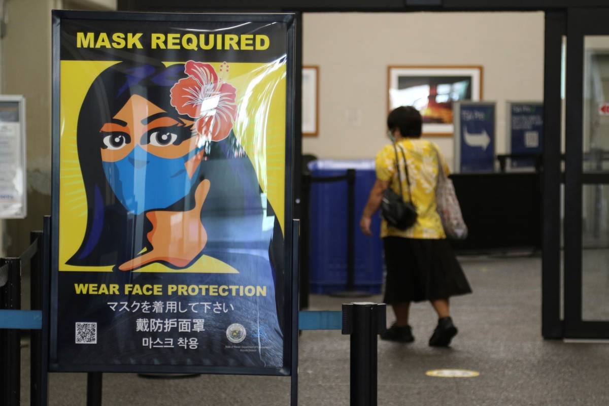 A woman walks into the international airport in Honolulu in October 2020. (AP Photo/Caleb Jones)
