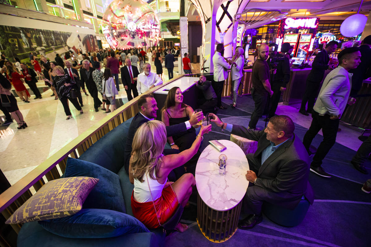 People toast and mingle at Gatsby's cocktail lounge during the opening night of Resorts World L ...