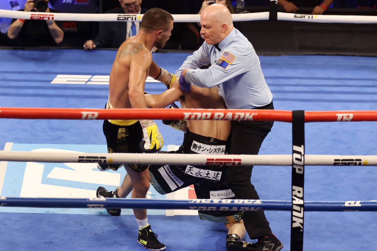 Vasyl Lomachenko, left, looks as the referee steps in to stop the fight against Masayoshi Nakat ...