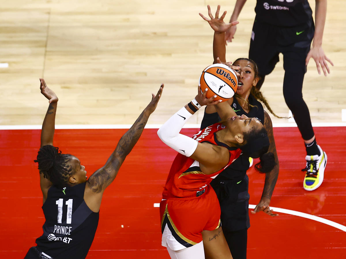 Las Vegas Aces' A'ja Wilson, center, shoots under pressure from Seattle Storm's Epiphanny Princ ...