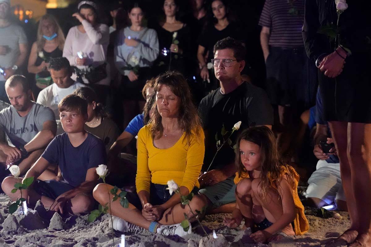People gather at a vigil, late Monday, June 28, 2021, in Surfside, Fla. The vigil remembered th ...