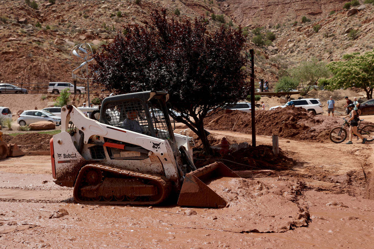 Workers clear mud and debris in Zion Canyon Village in Zion National Park near Springdale, Utah ...