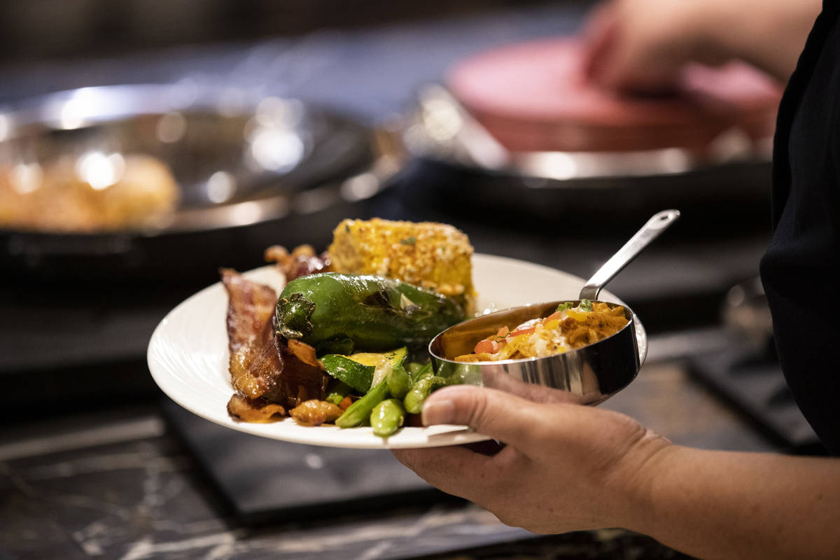 A person serves their own food at The Buffet at Wynn Las Vegas, Wednesday, June 30, 2021 in Las ...