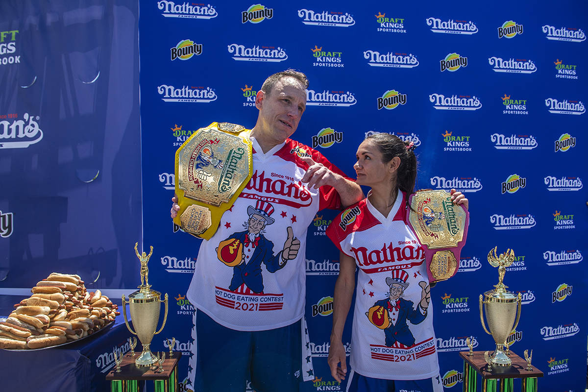 Winners Joey Chestnut and Michelle Lesco pose with their championship belts and trophies at the ...