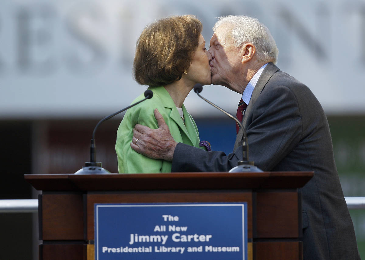 FILE - This Oct. 1, 2009 file photo shows former President Jimmy Carter getting a kiss from his ...
