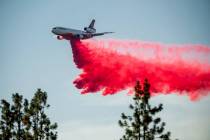 A DC-10 air tanker drops retardant while battling the Salt Fire near the Lakehead community of ...