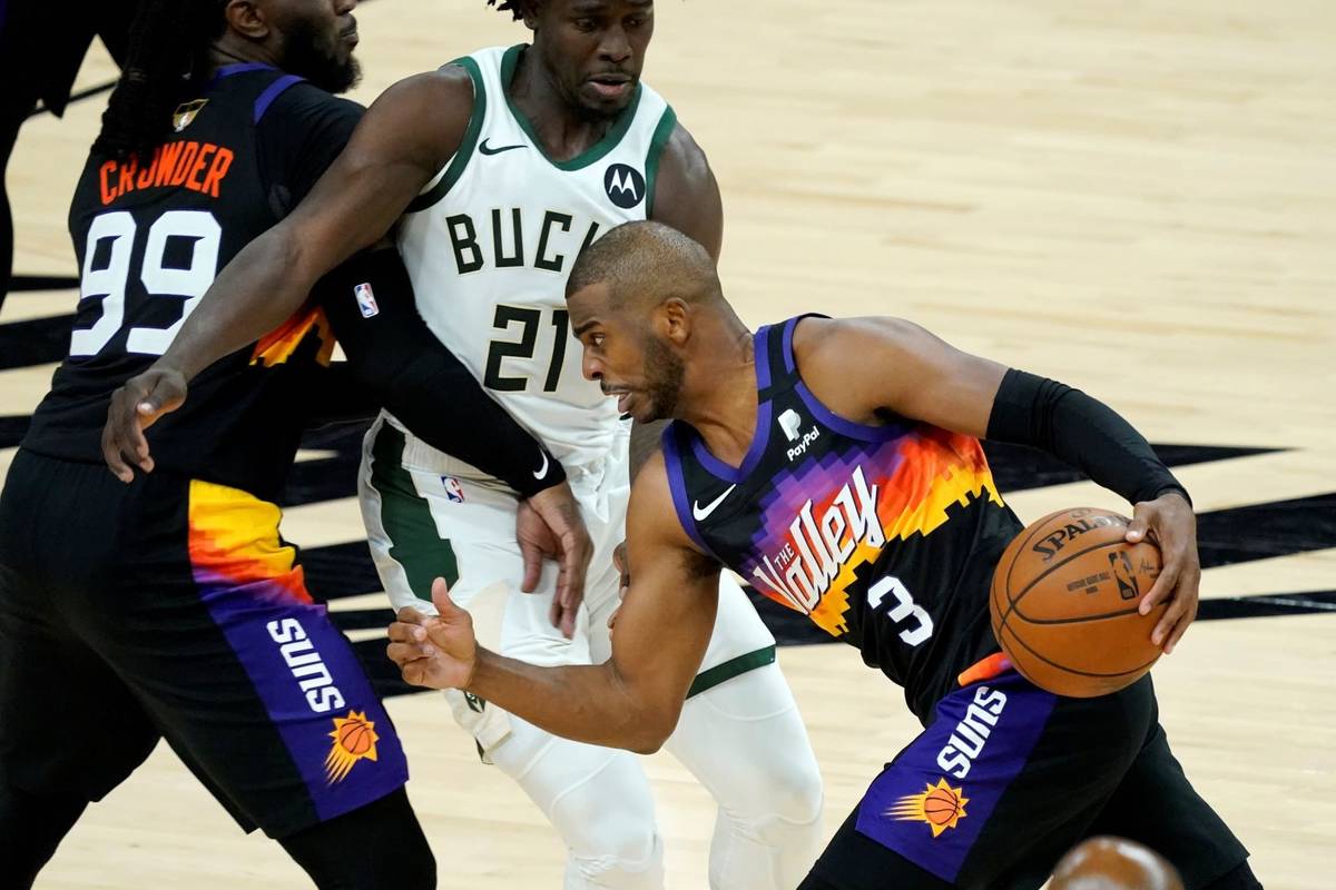 Phoenix Suns guard Chris Paul (3) drives pst Milwaukee Bucks guard Jrue Holiday (21) during the ...