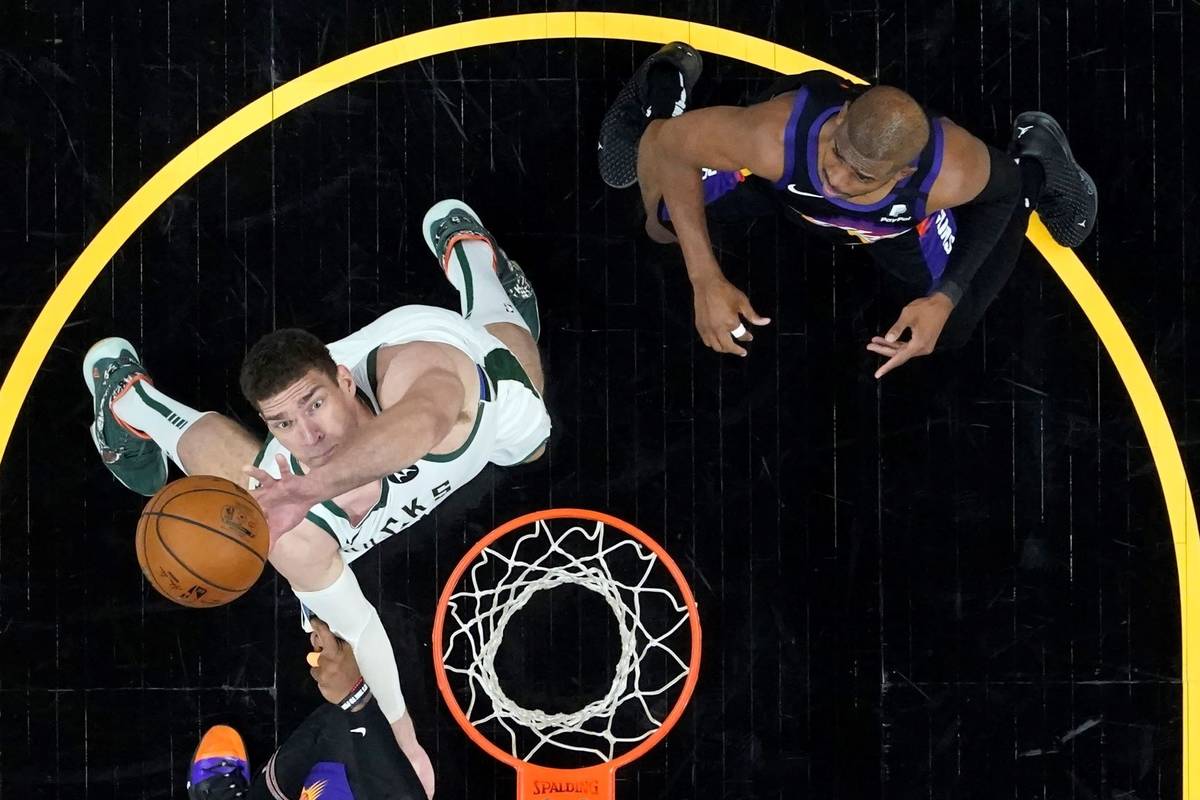 Milwaukee Bucks center Brook Lopez rebounds as Phoenix Suns guard Chris Paul, right, looks on d ...