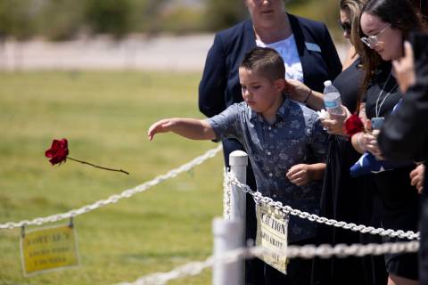 Noah Swanger, 8, tosses a rose on the gravesite of his father, Nevada National Guard member and ...