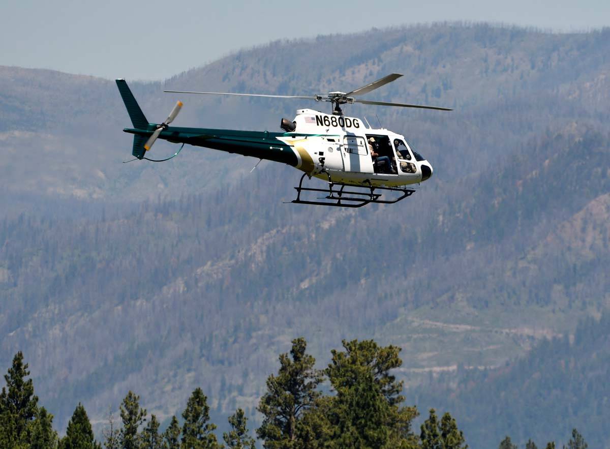 A helicopter from Montana Fish, Wildlife and Parks flies around the Ovando, Mont., area on Tues ...