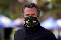 California Gov. Gavin Newsom wears a mask during a visit to a vaccination center in South Gate, ...