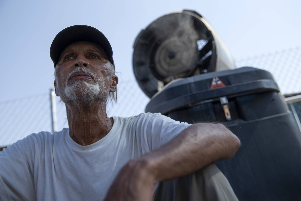 Jordan Patrick Andrews, of Las Vegas, sits beneath a misting fan at Courtyard Homeless Resource ...