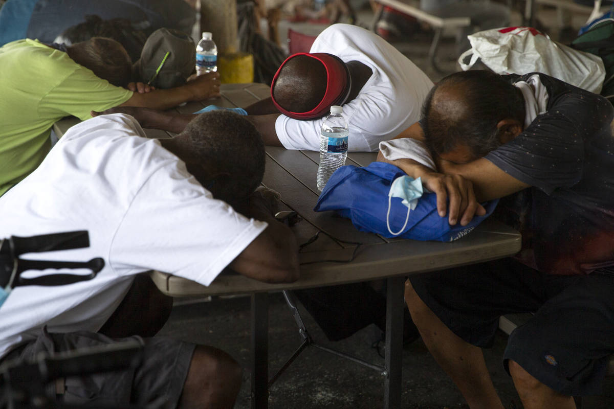 People attempt to rest in the shade at Courtyard Homeless Resource Center on Saturday, July 10, ...