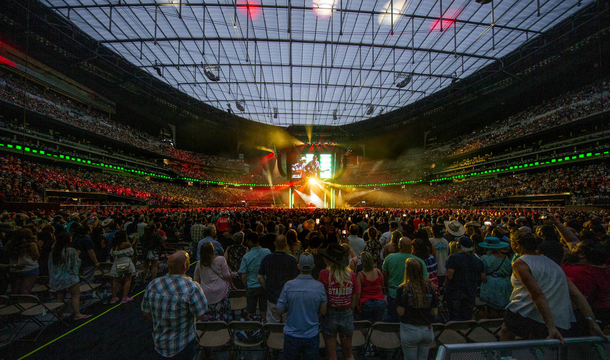 Fans stand and sing as Garth Brooks performs before the crowd at Allegiant Stadium on Friday, J ...