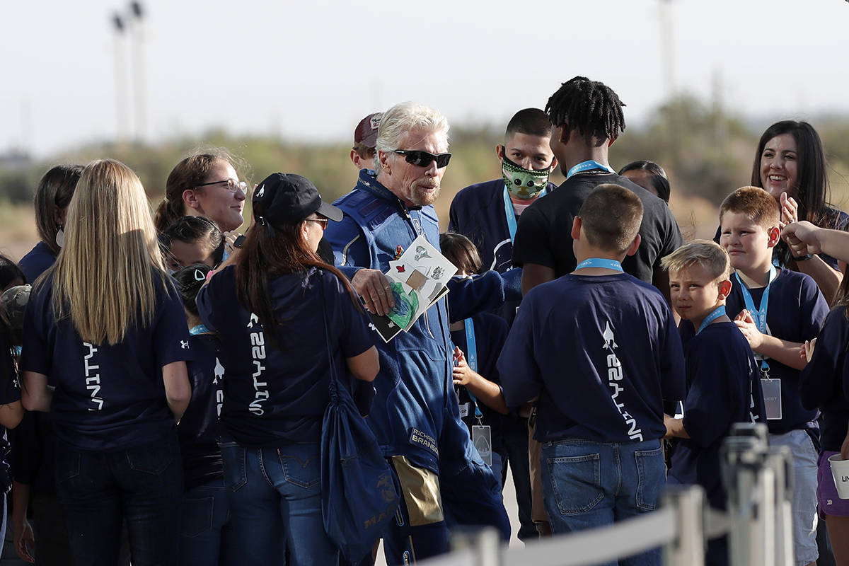 Virgin Galactic founder Richard Branson is greeted by school children before heading to board t ...
