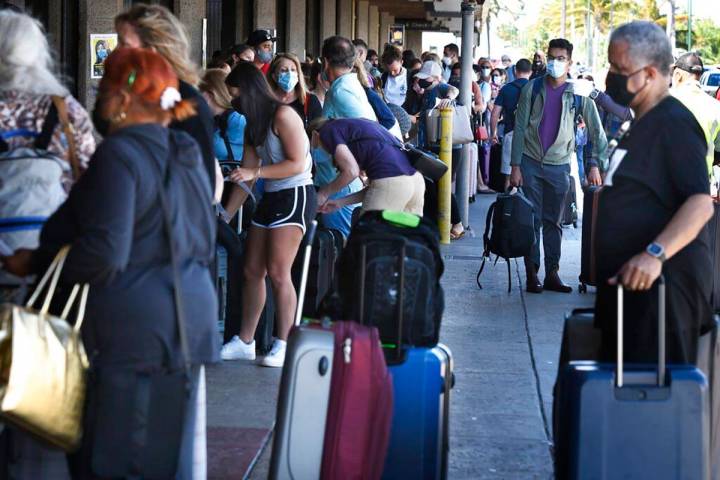 A long line of travelers wait to pass through a state agriculture inspection at the Kahului Air ...