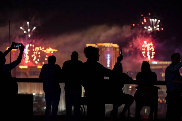Spectators watch as fireworks explode over the Las Vegas Strip during a 4th of July Fireworks s ...