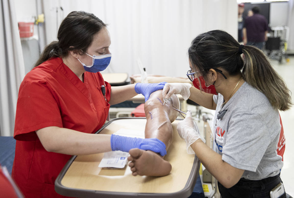 Northwest Career And Technical Academy student Natalie Sanchez, right, works to remove sutures ...