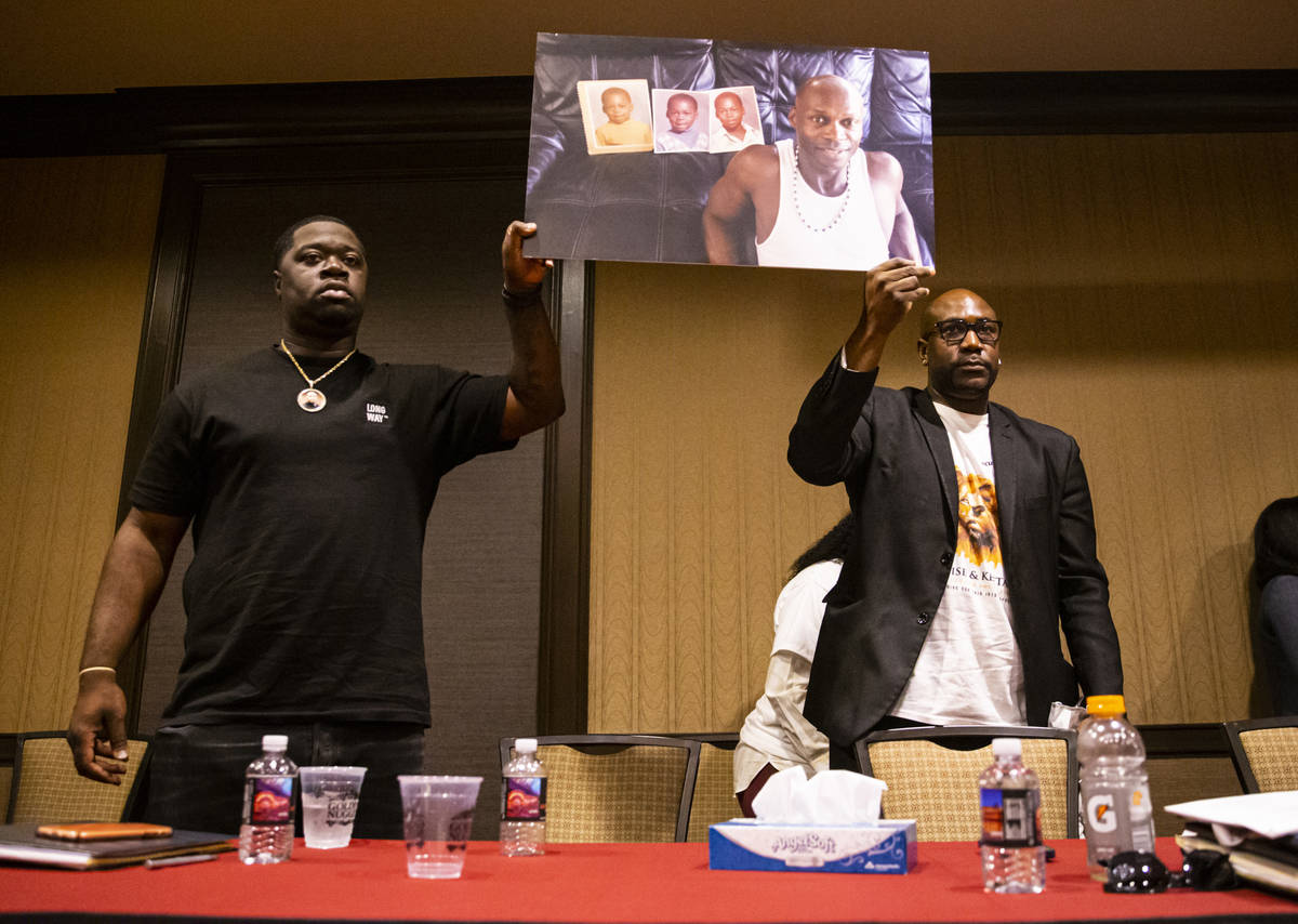 George Floyd's brother, Philonise, left, and his nephew, Brandon Williams, hold up a portrait o ...