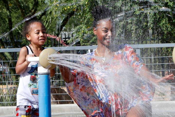 Diamond Cook of Las Vegas plays with her son Lincoln Carter, 3, in the splash pad at Baker Park ...