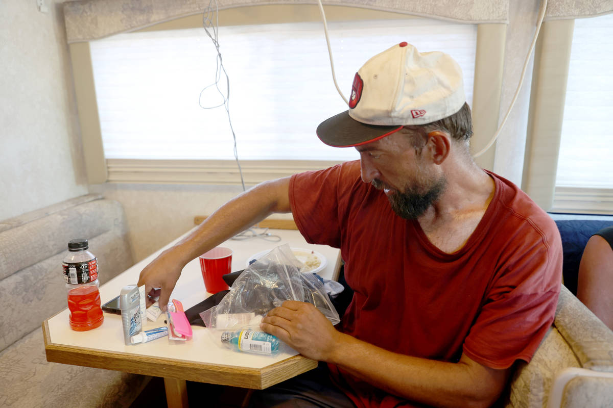 Eric Gutierrez, 39, organizes his toiletries while waiting for a shower in an RV operated by Cu ...