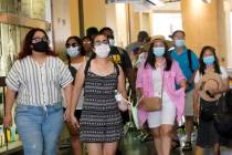 Visitors wear masks as they walk in a shopping district in the Hollywood section of Los Angeles ...