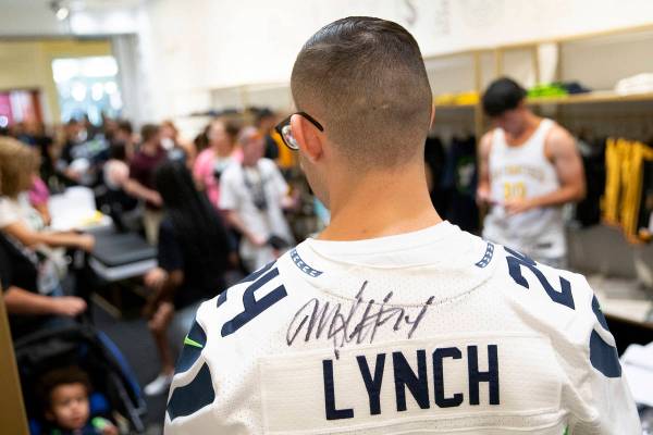 Esteban Soto, of Las Vegas, shows off his autographed Marshawn Lynch jersey at the opening of t ...