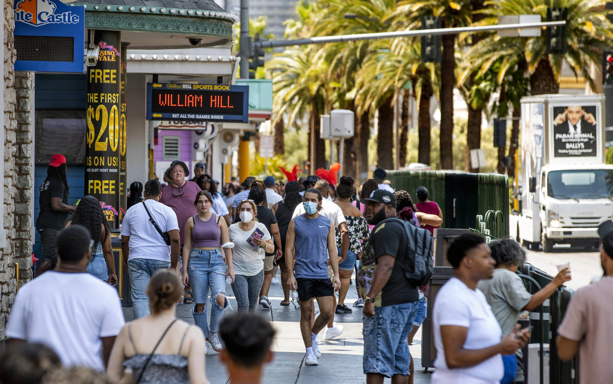 People walk along the Strip near The Venetian, most not wearing masks, on Friday, July 16, 2021 ...