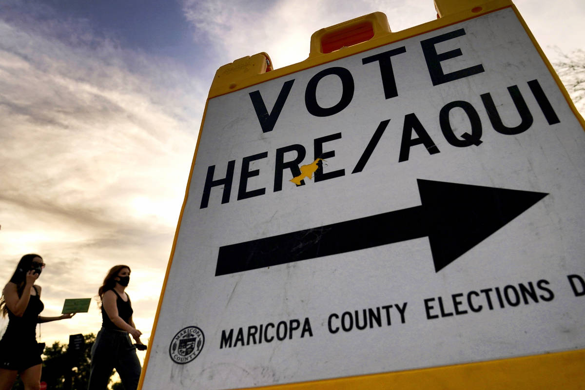 In this Nov. 3, 2020, file photo voters deliver their ballot to a polling station in Tempe, Ari ...