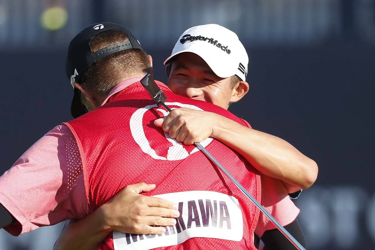 United States' Collin Morikawa celebrates with his caddie Jonathan Jakovac on the 18th green af ...