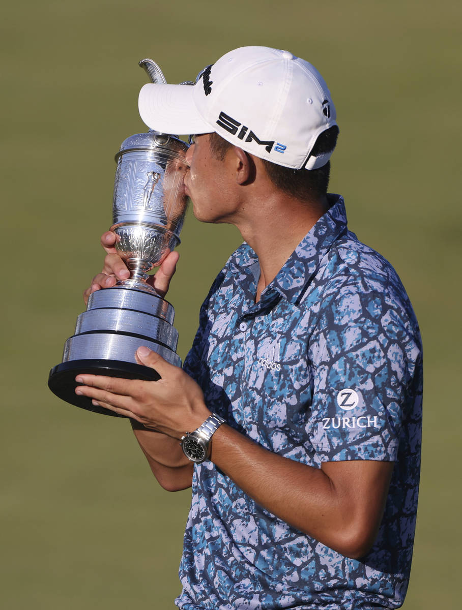 United States' Collin Morikawa kisses the claret jug trophy as he poses for photographers on th ...