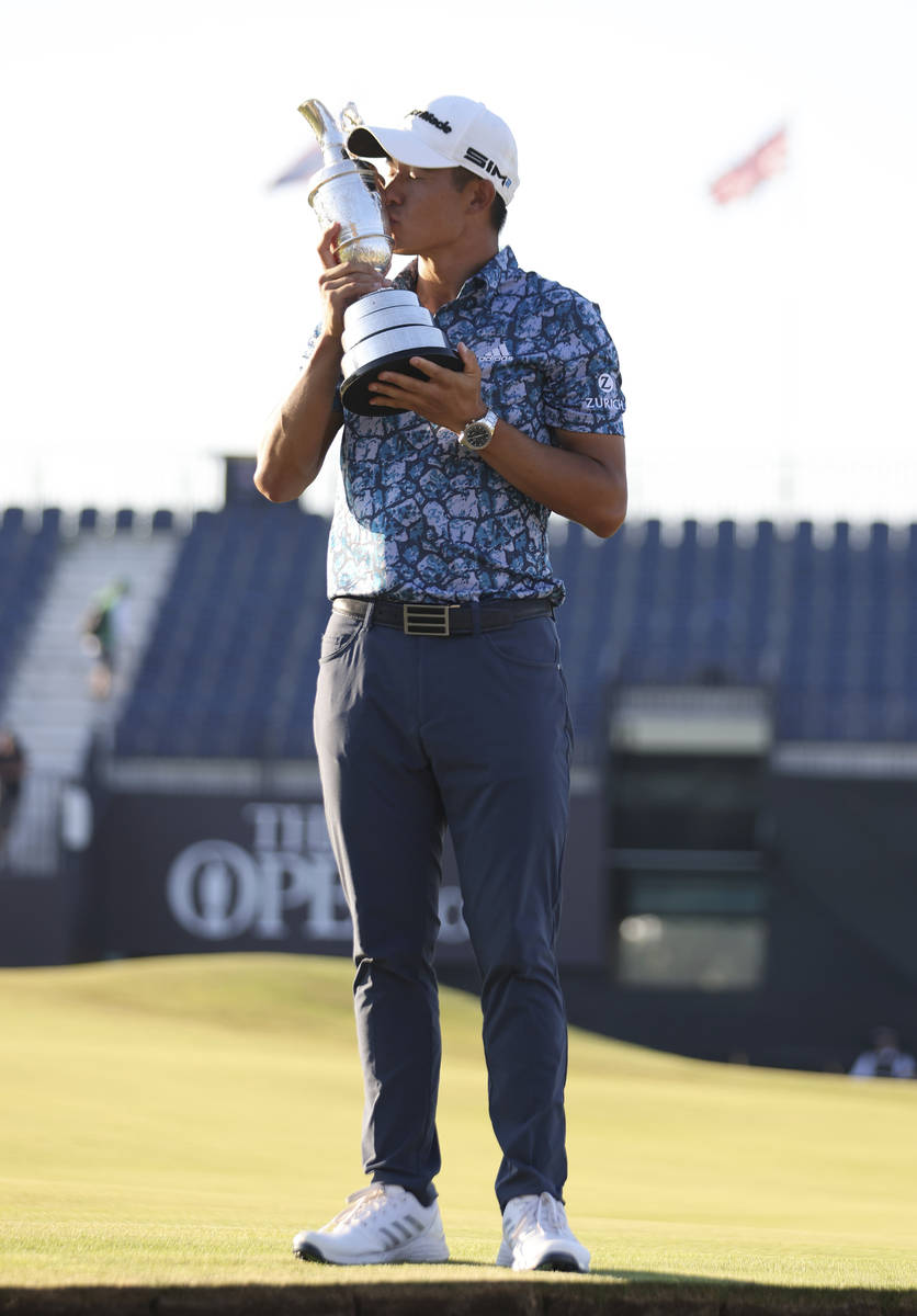 United States' Collin Morikawa holds up the claret jug trophy as he poses for photographers on ...