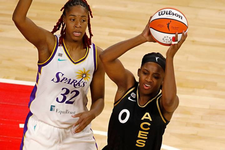 Las Vegas Aces guard Jackie Young (0) looks to pass against Los Angeles Sparks guard Bria Holme ...