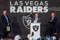 Governor Steve Sisolak, left, looks to Las Vegas Raiders owner Mark Davis who addresses the cro ...