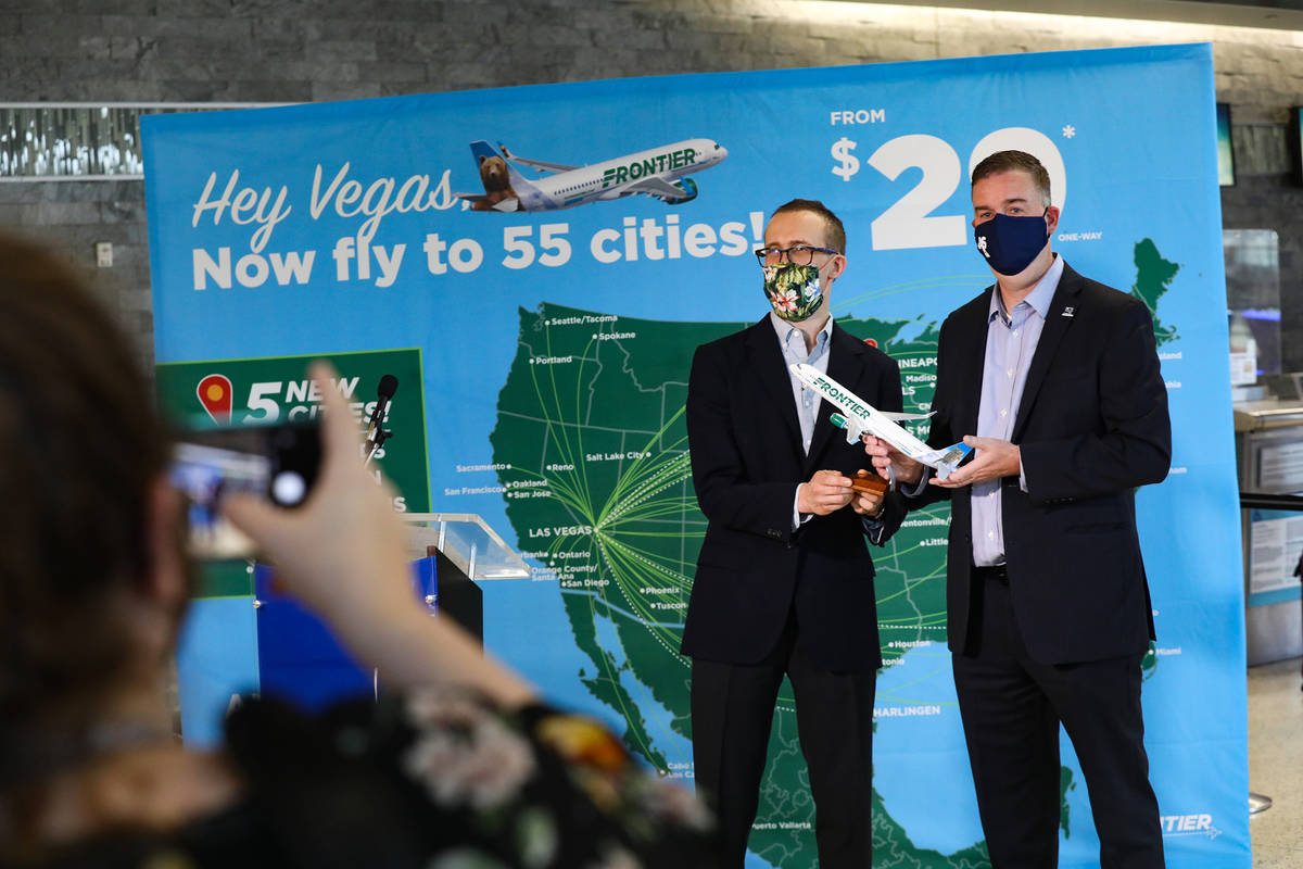 Daniel Shurz, senior vice president of commercial Frontier Airlines, left, takes a photo with C ...