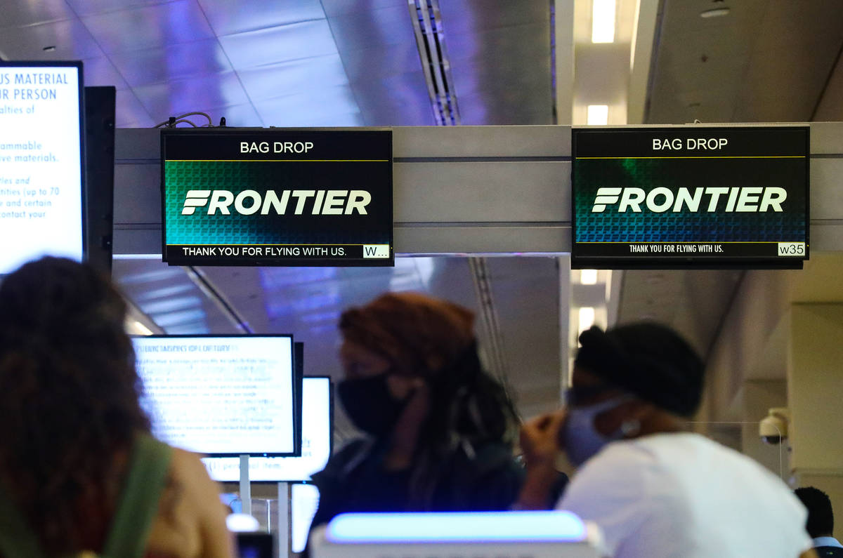 Guests check in at the Frontier counter in terminal three of McCarran International Airport in ...