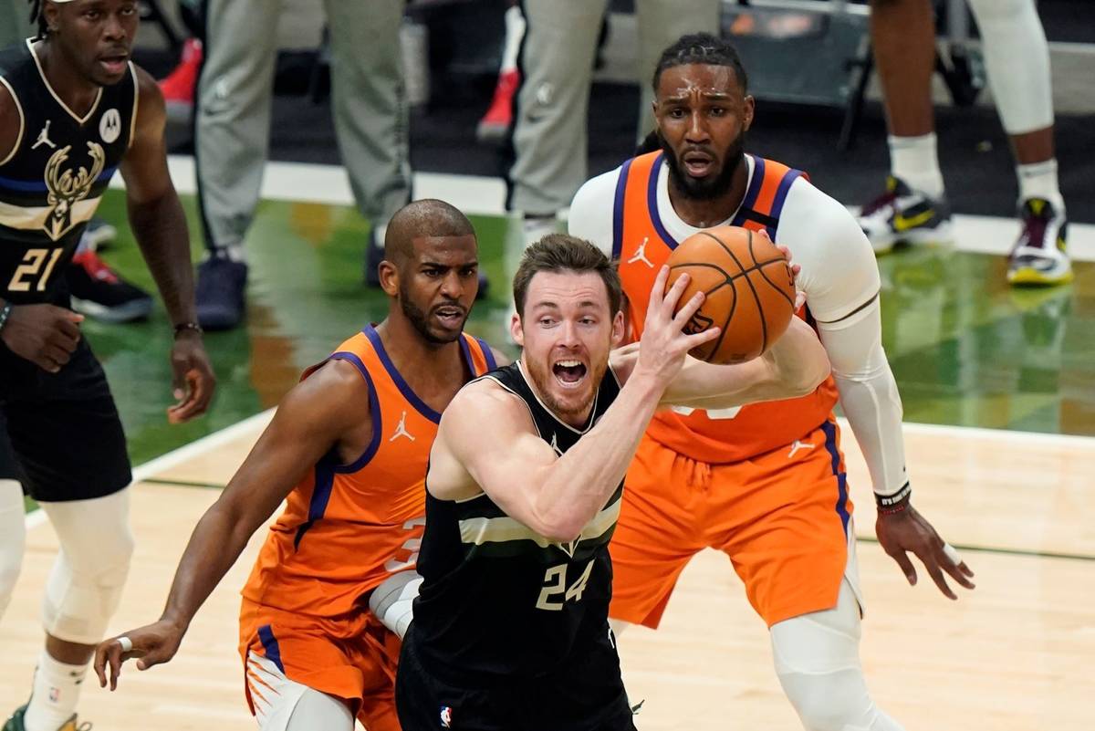 Milwaukee Bucks guard Pat Connaughton (24) looks to pass under pressure from Phoenix Suns guard ...