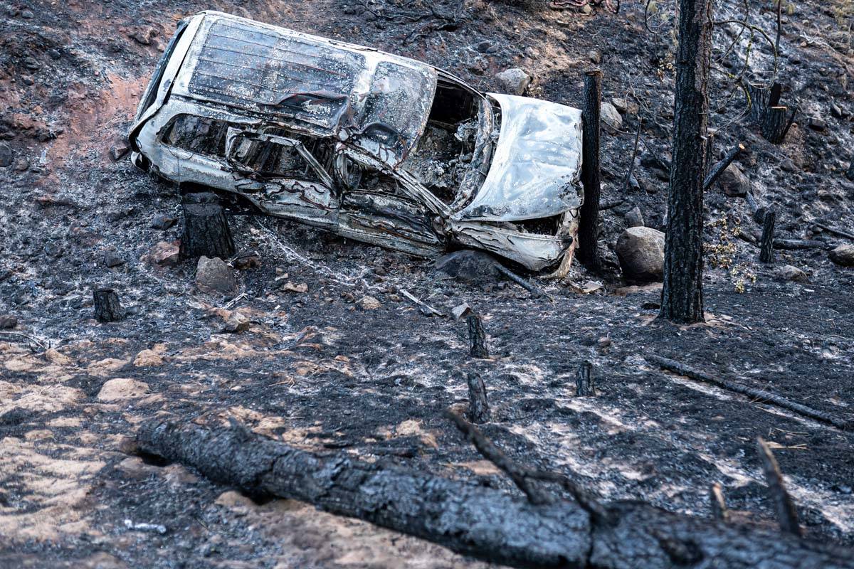 A burned car damaged by the Bootleg Fire is seen here along a mountain road on Wednesday, July ...