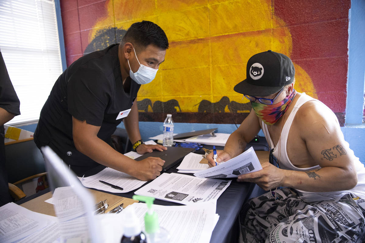 Francisco Ortiz, left, with Impact Health, assists Dino Poston with his intake information for ...