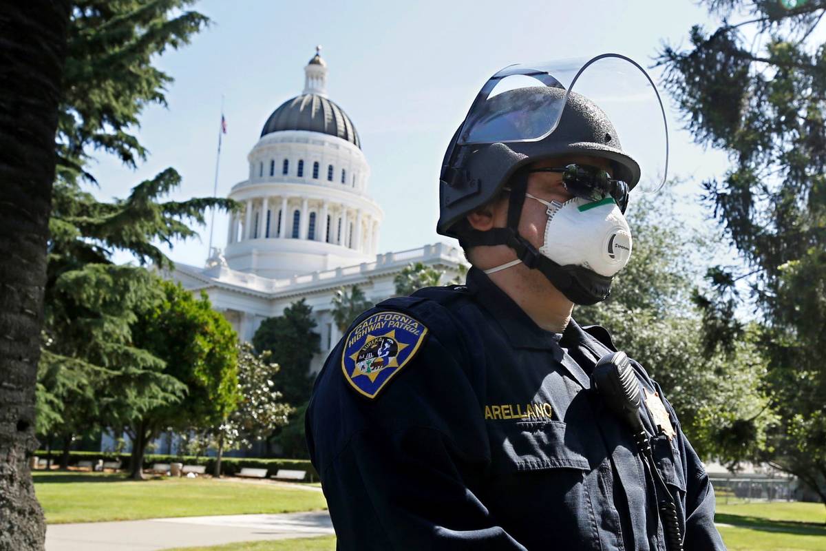 California Highway Patrol Officer S. Arellano wears a face mask at the the state Capitol in Sac ...