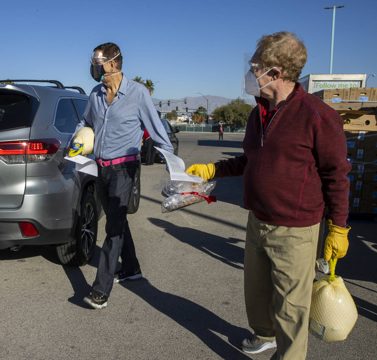 Penn & Teller carry over turkeys and cookies to awaiting vehicles during the re-opening of the ...
