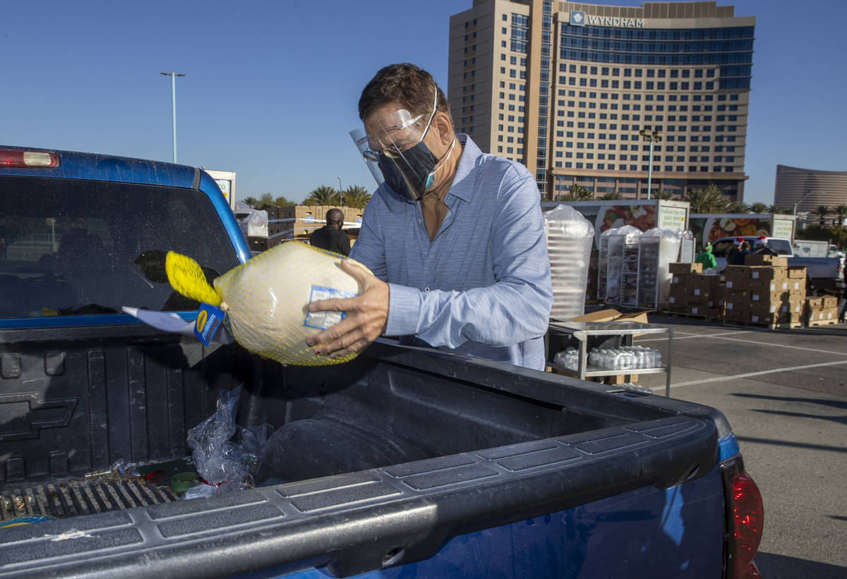 Penn Jillette delivers a turkey and cookies to an awaiting vehicle during the re-opening of the ...