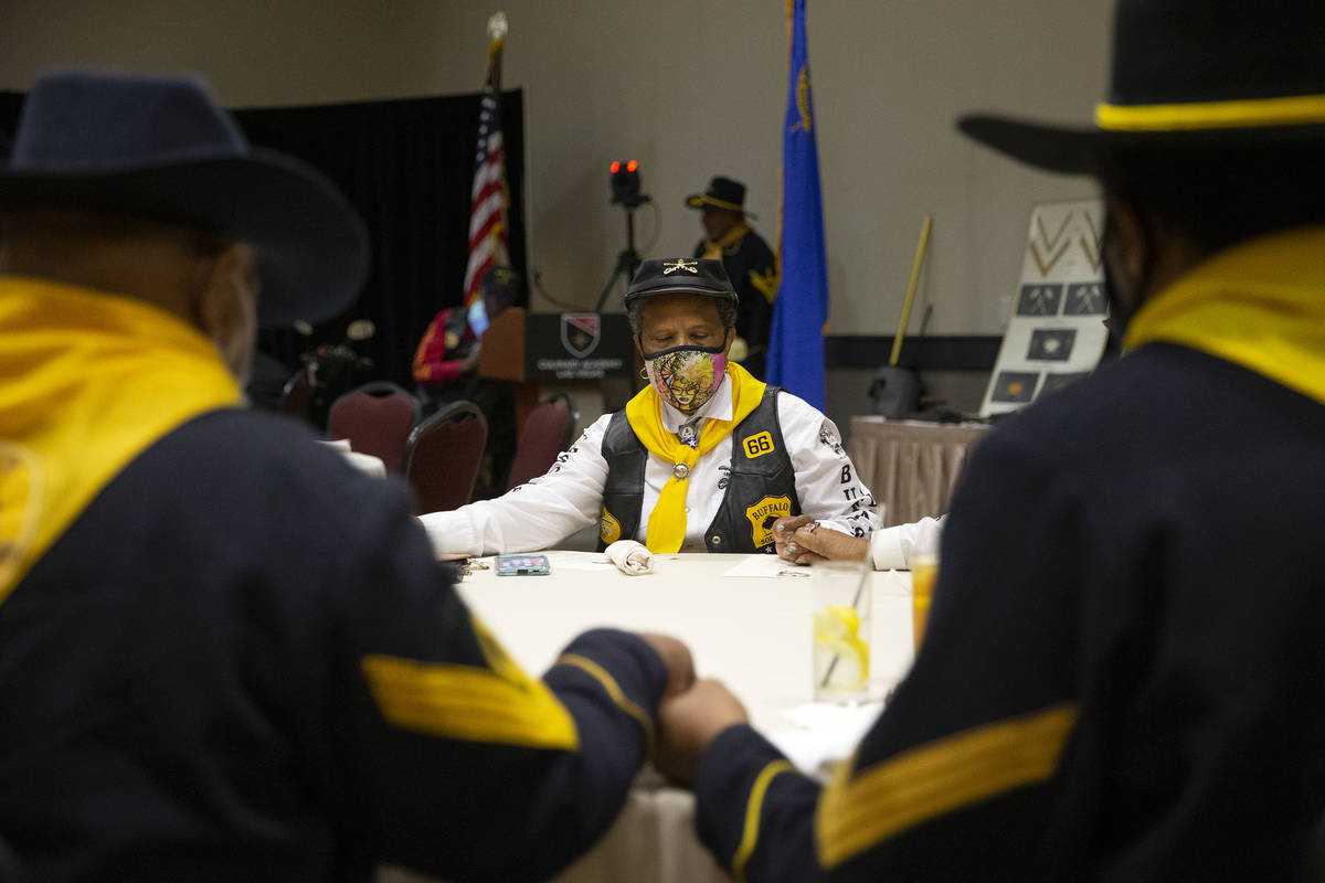 Dora Macklin, center, a member of the Buffalo Soldiers, bows her head in prayer during an event ...