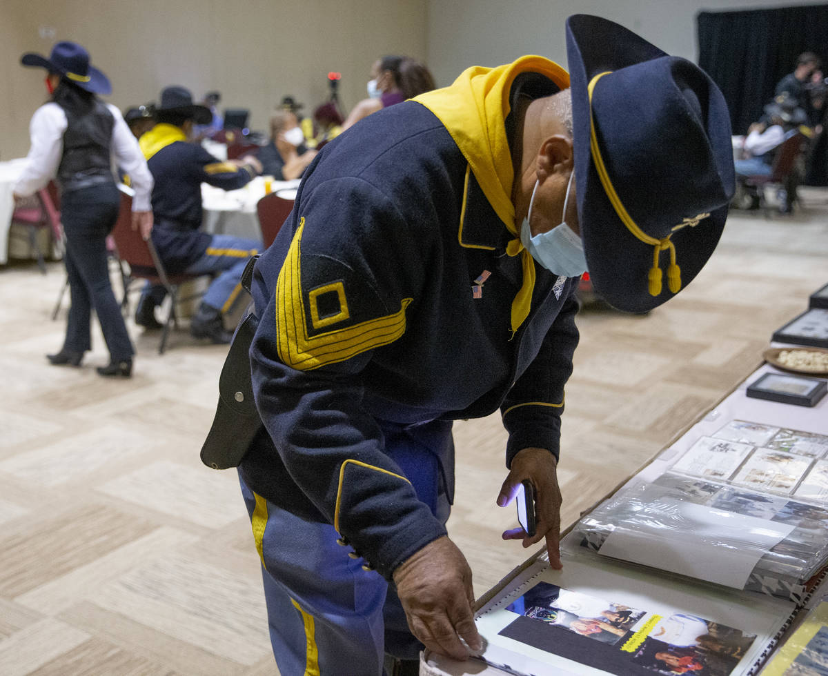 Mitchell Sayles, a member of the Buffalo Soldiers, pages through a scrapbook during an event fo ...