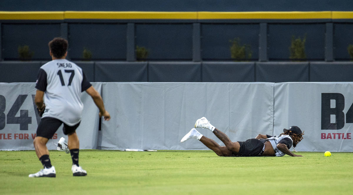 Las Vegas Raiders Damon Arnette (20, right) misses a long fly ball as teammate Willie Snead IV ...