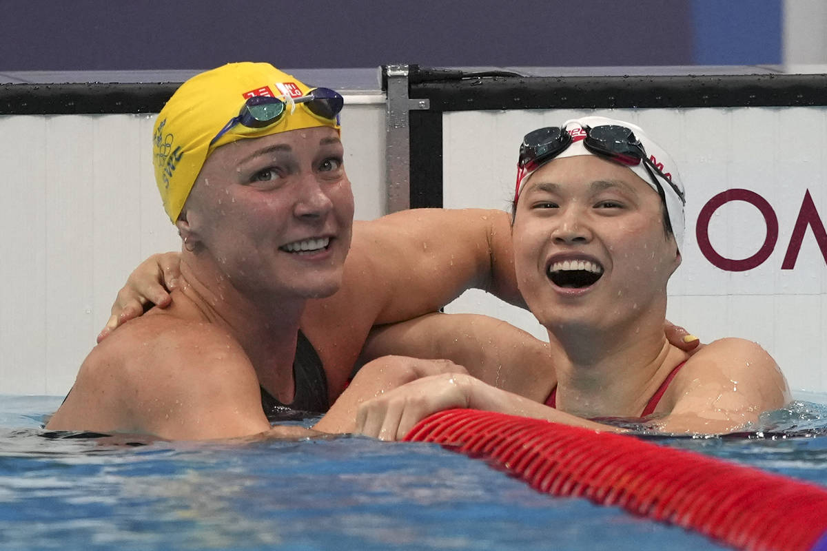 Margaret MacNeil, right, of Canada, is congratulated by Sarah Sjoestroem of Sweden103 after win ...