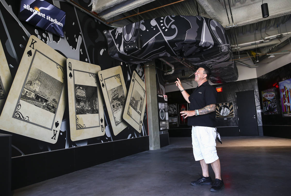 Artist Michael Godard, who curated the Allegiant Stadium art collection, shows off one of the a ...