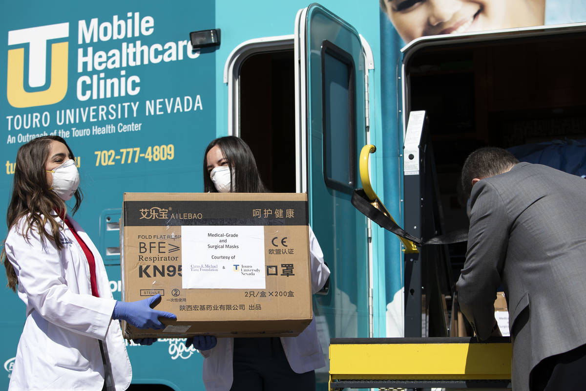Touro University Nevada medical students help to unload at Henderson Hospital on Wednesday, Apr ...